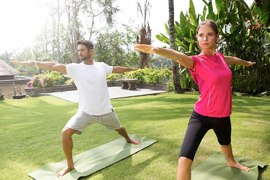 Couple in Viceroy retreat Bali does yoga.