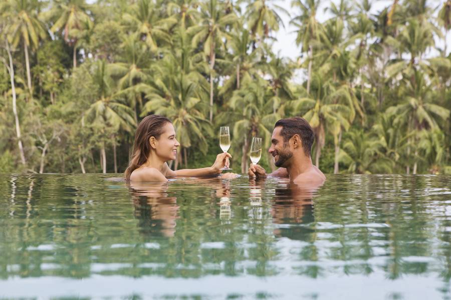 A couple enjoying a wine in the pool on their valentines day package in Bali