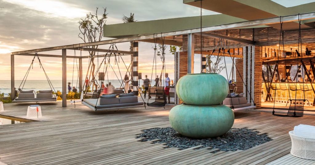 The deck area with hanging chairs  and luxury decor at the Como Uma in Canggu