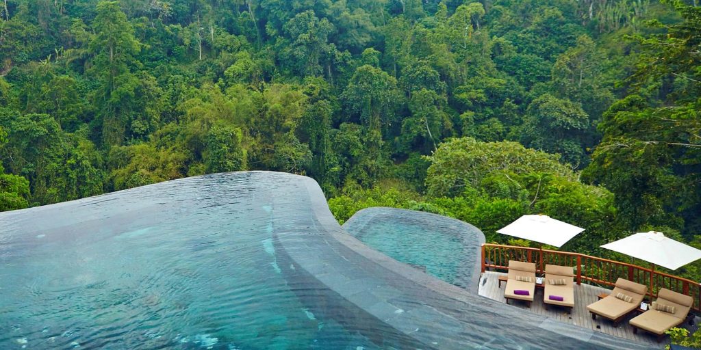Two pools overhanging the jungle, deck and deck chairs at Hanging Gardens Of Bali