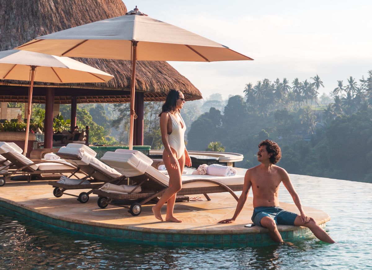 A couple romantically gazing at each other next to an infinity pool in Bali