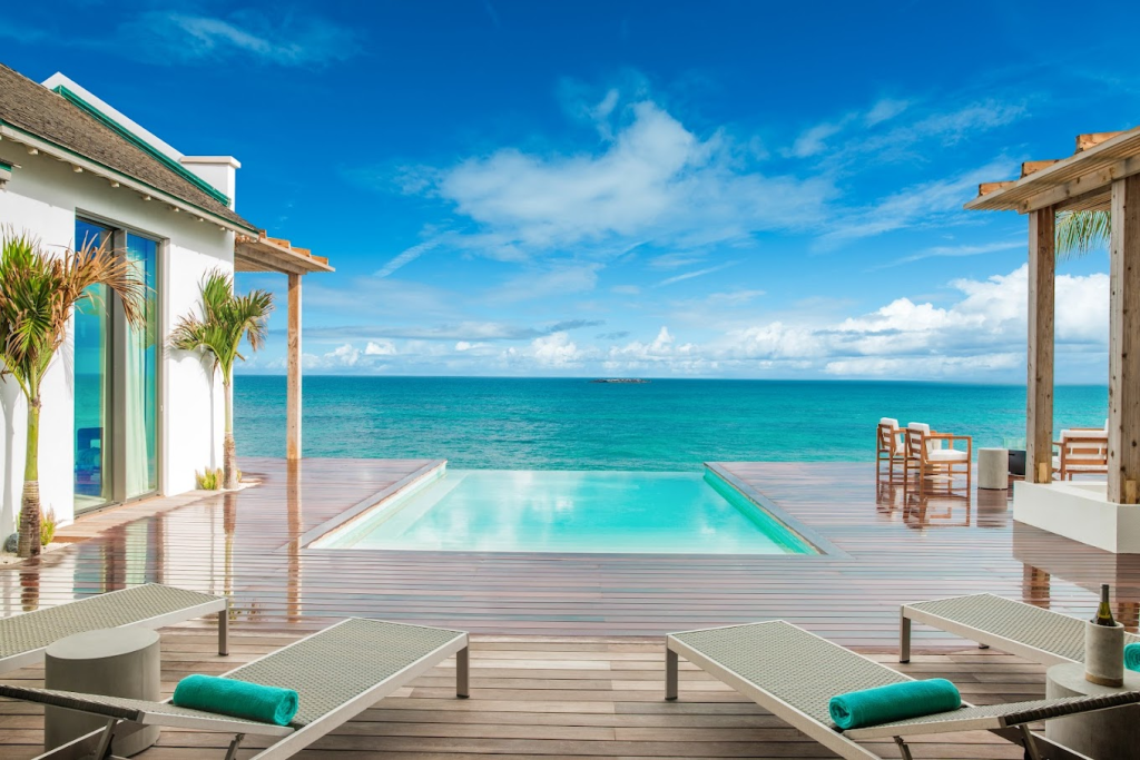 View of the pool and ocean from the deck of Ambergris Cay Private Island Resort in Turks & Caicos