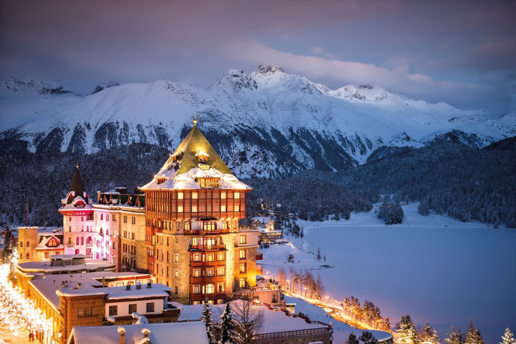 Aerial view of Badrutt’s Palace in Switzerland with snow-capped mountains in the background
