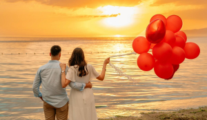 A couple holding balloons on a beach in Bali