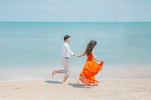 A couple running along a beach in Bali