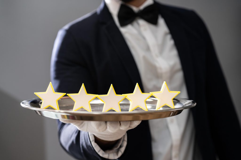 A butler holding a 5 stars on a plate