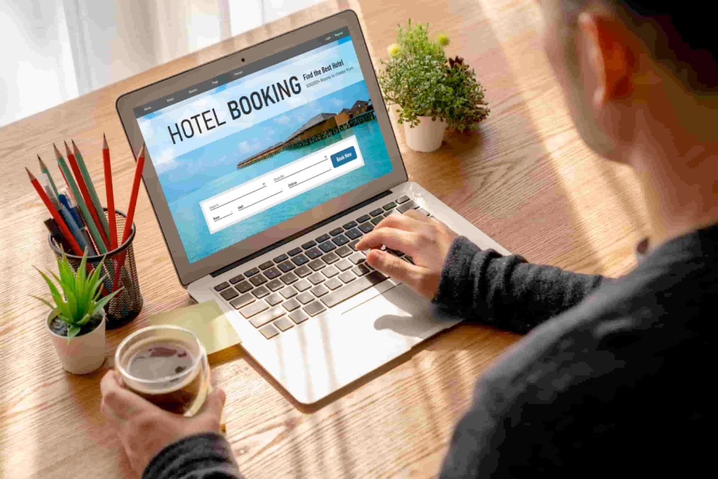 A man using a computer to book a hotel