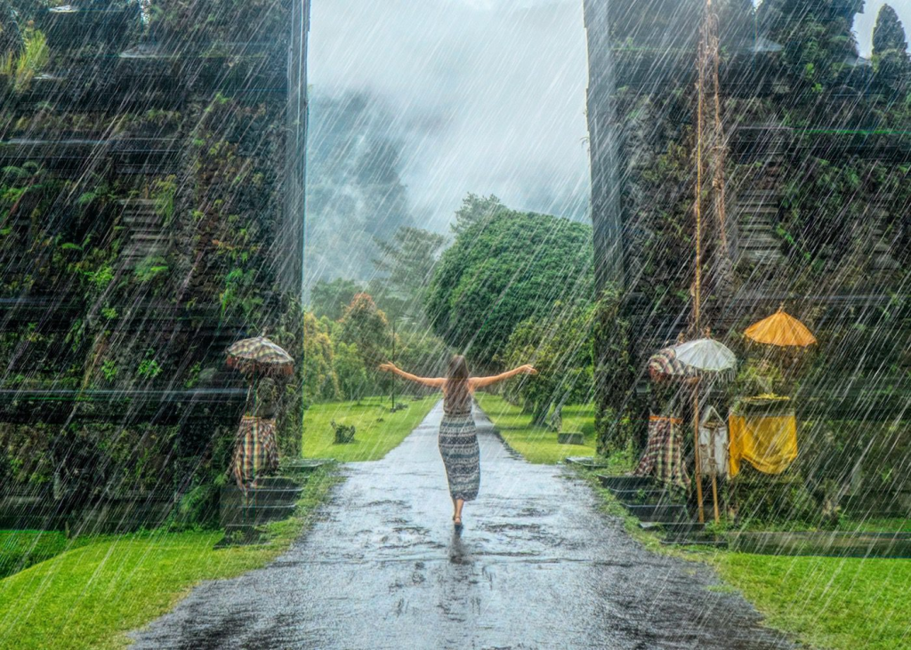 A woman standing outside in Bali while it is raining