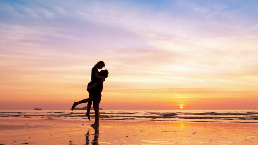 A couple hugging on a Bali beach on their honeymoon