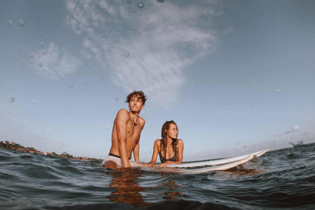 A couple surfing on their honeymoon in Bali