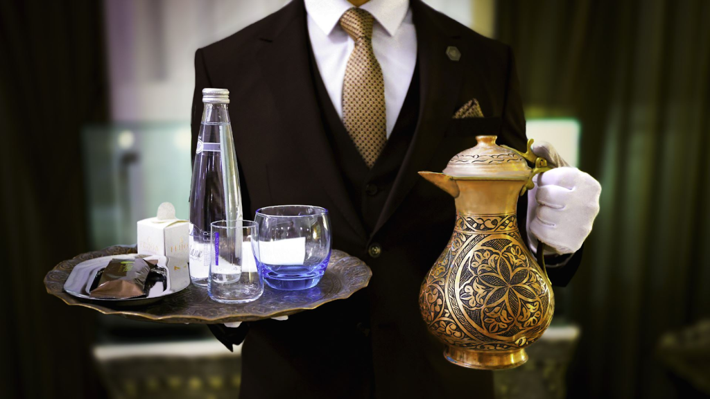 A butler carrying drinks to a hotel guest