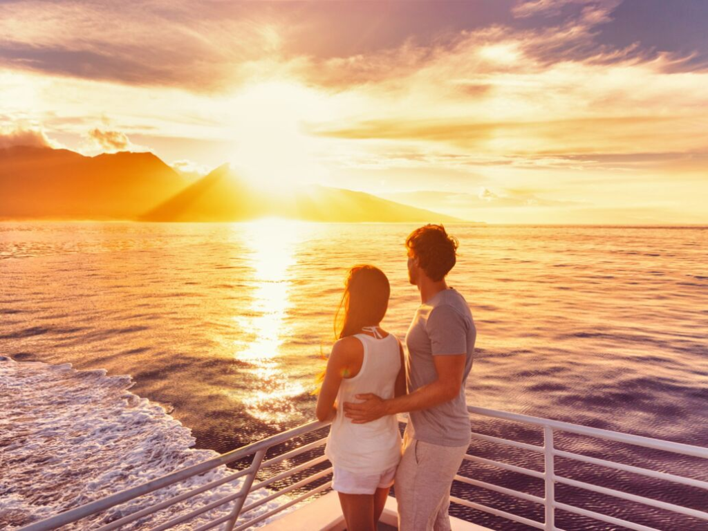 A couple on their honeymoon watching the sunset from a boat in Hawaii