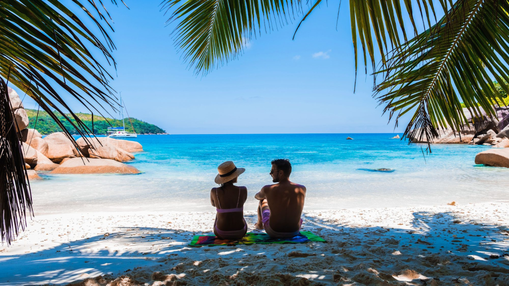A couple sitting on the beach on their honeymoon