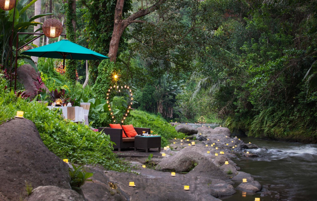 A romantic dinner set up by the river at The Samaya Ubud