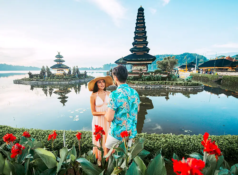 A couple on their honeymoon standing in front of a water temple in Bali
