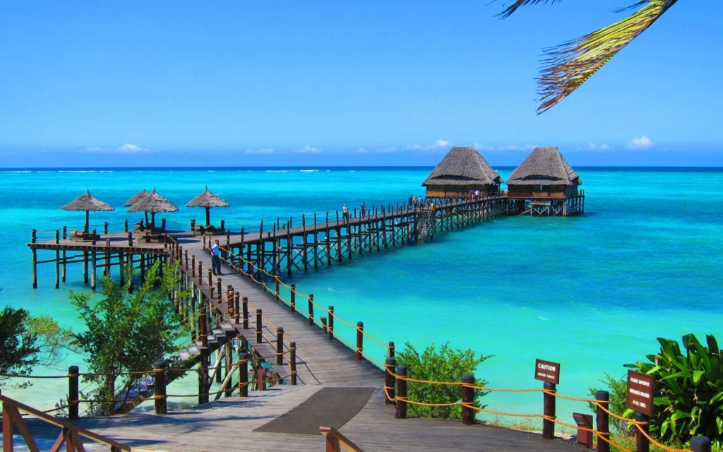 Two bungalows on the water in Zanzibar with turquoise and blue water