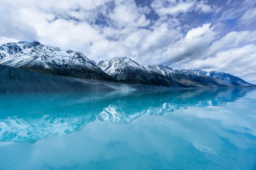 Snow capped mountains next to a blue lake in New Zealand
