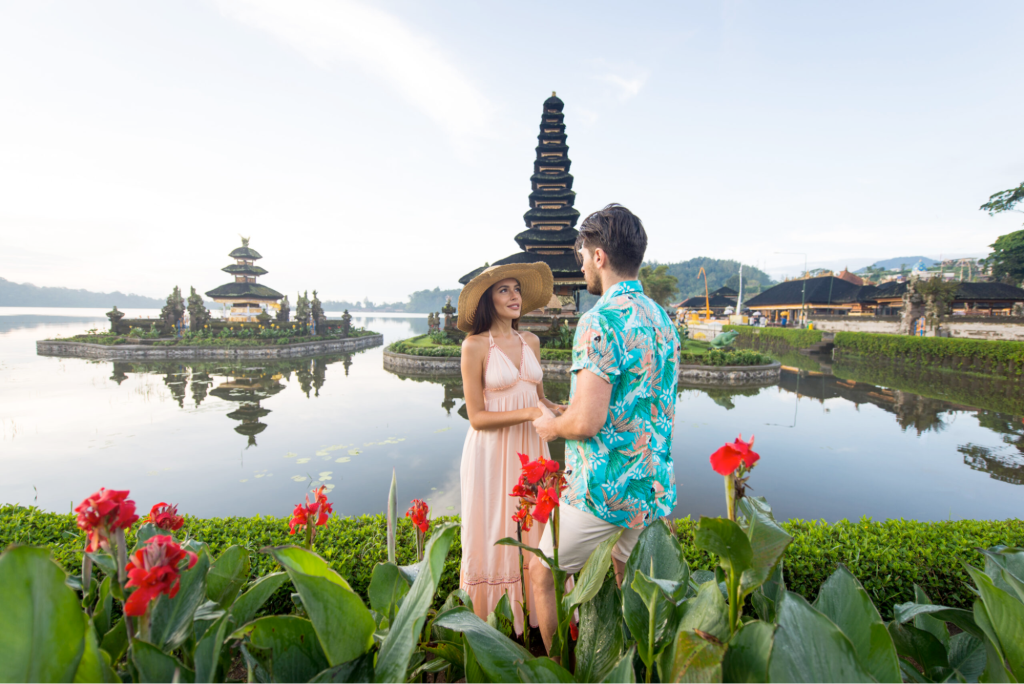 A couple holding hands in front of a water temple in Bali