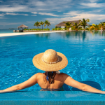 A woman relaxing on holiday in the pool of a luxury hotel