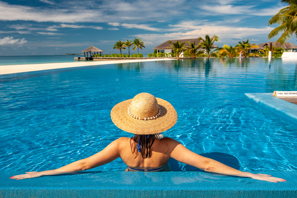 A woman relaxing on holiday in the pool of a luxury hotel